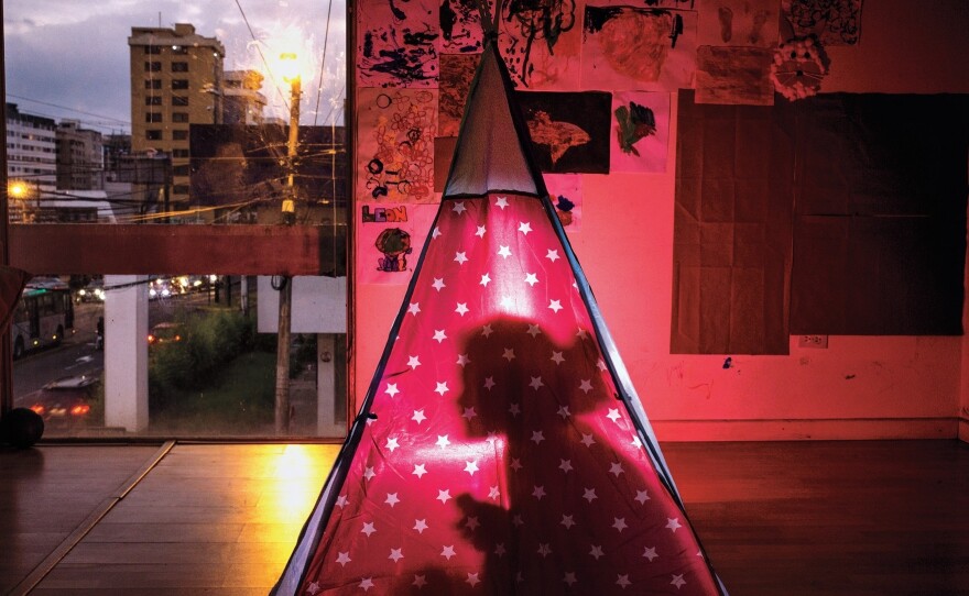 With the onset of the COVID-19 virus, 4-year-old Manuela Aguilar's education and school social life in Quito, Ecuador, changed dramatically. Here she plays with a flashlight, inside her camping tent, telling horror stories.