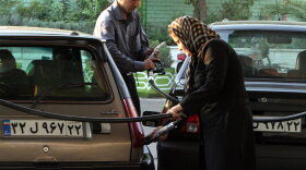 An woman and a man gas up their vehicles at a station in Tehran in 2007. Iran's economic problems are linked to its extensive use of subsidies — billions of dollars a year — to keep basic necessities such as gasoline below their true market value.