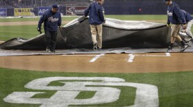 Rain forces the grounds crew at Petco Park to cover the infield during the first inning of a game between the San Diego Padres and the Washington Nationals, May 14, 2015. The rain delay lasted nearly two hours.
