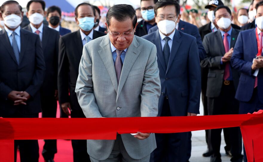 Cambodia's Prime Minister Hun Sen cuts a ceremonial ribbon for a stadium in Phnom Penh paid for by China's Belt and Road Initiative in this December 2021 photo.