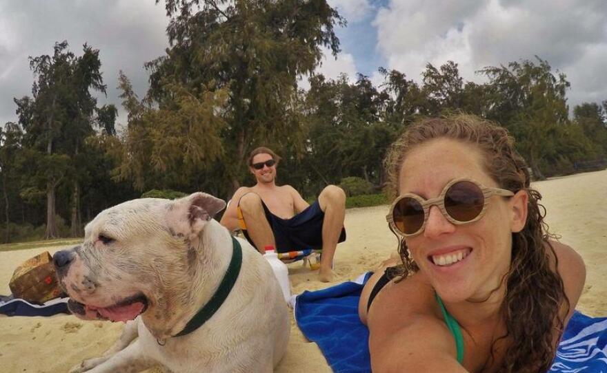 Mary Finley, Travis Sherman and their dog Tonka sit on the beach in this undated photo. 