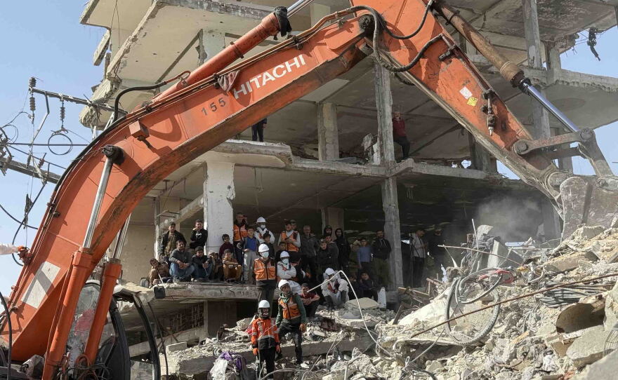 Family members, neighbors, and a civil defense crew observe the search and recovery operation aimed at removing rubble and recovering the bodies of victims from the Abu Naser family home in northern Gaza, after Israel targeted the house about a year and a half earlier.