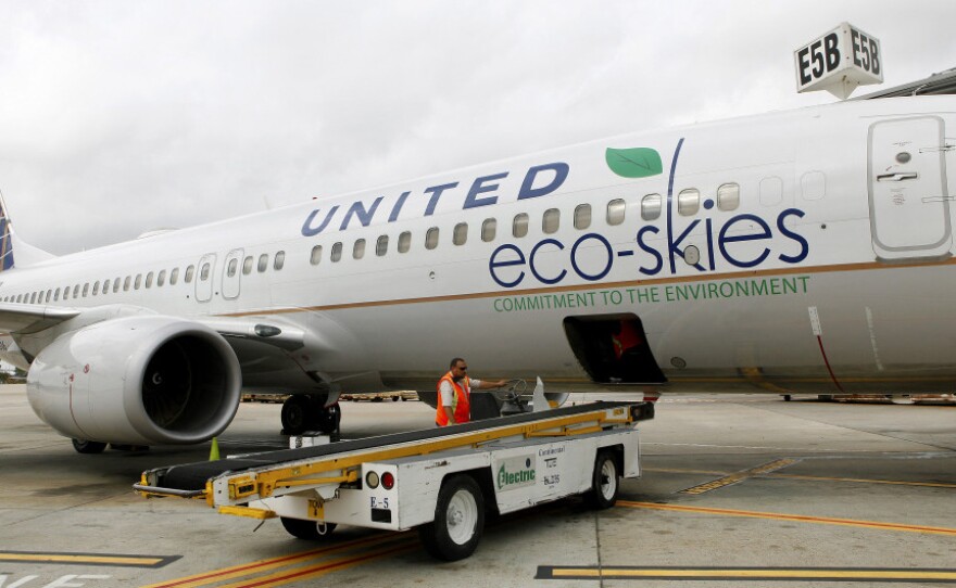 Employees load bags onto a Boeing 737-800 running on algae-based biofuel in Houston. Continental (owned by United Continental Holdings Inc.) flew the nation's first passenger jet powered by biofuels on Monday. 