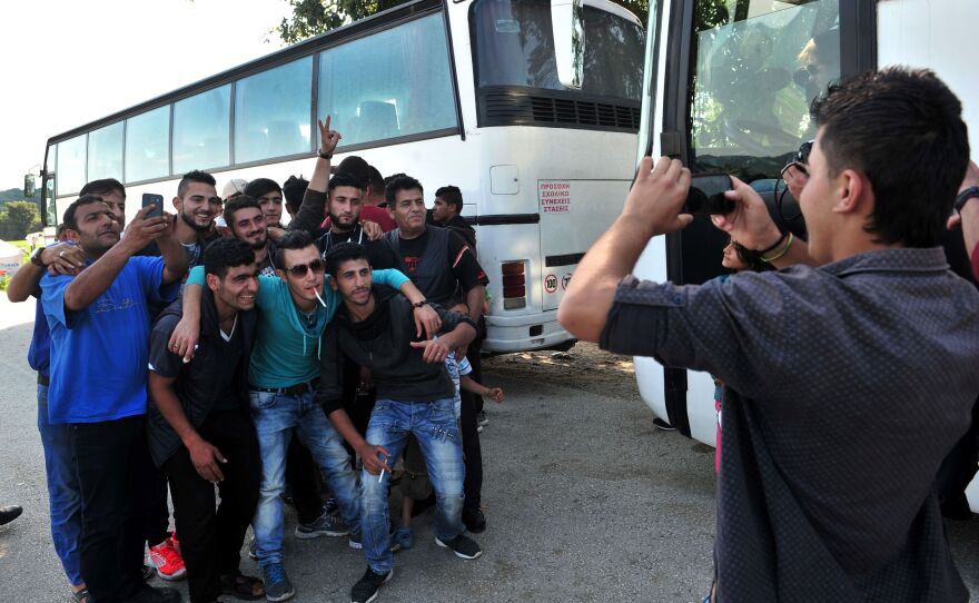 Men pose for a photo on Monday as some of them prepare to leave the squalid camp.