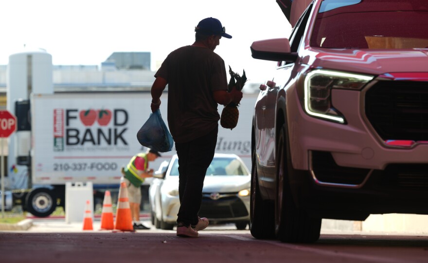 El voluntario Joel Hernandez ayuda a cargar un vehículo durante una actividad de distribución de alimentos dirigida a los hogares de empleados federales afectados por el cierre del gobierno, así como a beneficiarios del SNAP, el lunes 27 de octubre de 2025, en San Antonio. (AP Foto/Eric Gay)