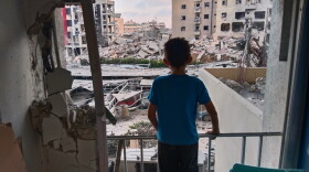 A boy looks through a damaged room of the Jabal Amel Hospital into a destroyed building that was hit in an Israeli airstrike in the southern port city of Tyre, Lebanon, June 1, 2026.
