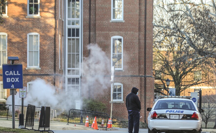 A man speaks with a police officer in a patrol vehicle outside the Spelman campus earlier this month after 17 historically Black colleges received bomb threats.