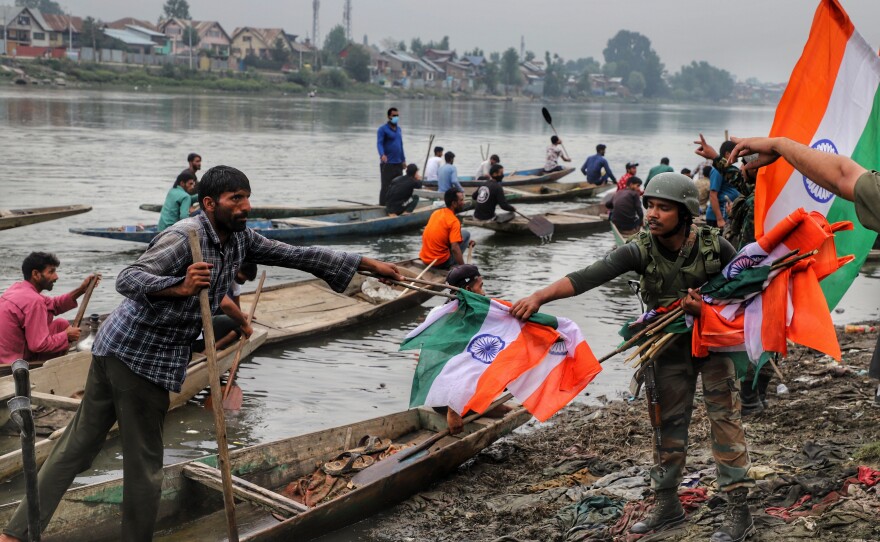 An Indian army soldier collects Indian national flags after a rally marking Indian independence in Sopore district, Baramulla, in Jammu and Kashmir, on Aug. 11.