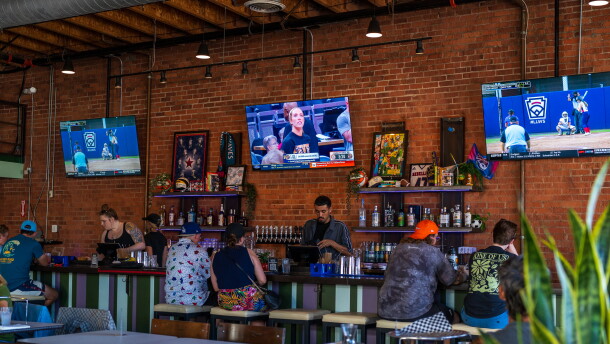 Customers sitting at the bar watch women's basketball and softball at One of Us in North Park on July 22, 2026. One of Us is San Diego's first women's sports bar.