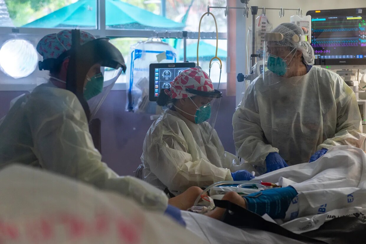 Scripps Health registered nurse Christina Campolongo (left), certified nursing assistant Vanessa Aquino and registered nurse Paloma Garza-Johnson turn a sedated coronavirus patient into the prone position, face down, which may allow more oxygen into the patient’s lungs. June 2020 at Scripps Mercy Hospital Chula Vista.