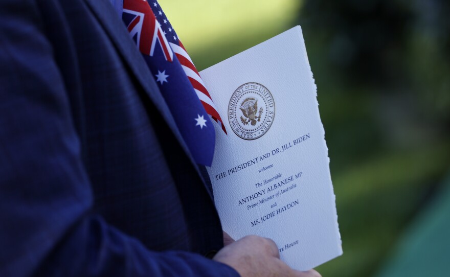 A guest on the South Lawn holds a program for the arrival ceremony for Australian Prime Minister Anthony Albanese at the White House.