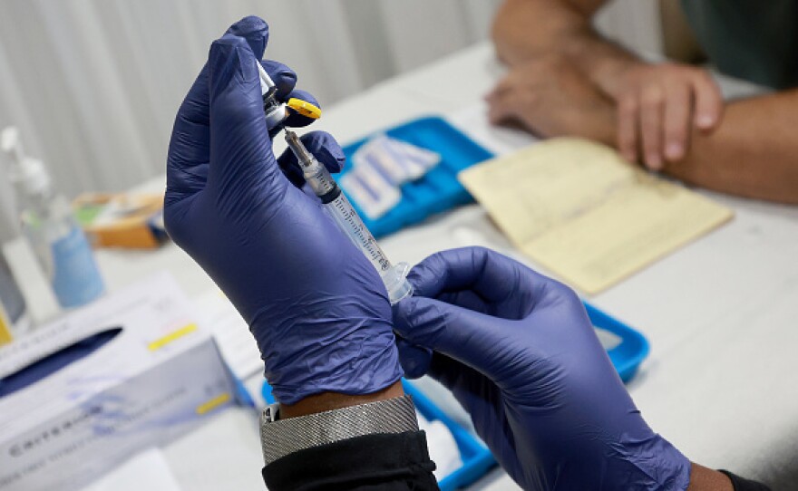 A health-care worker prepares to administer a free monkeypox vaccine in Wilton Manors, Florida. The question: Can vaccination slow the outbreak?