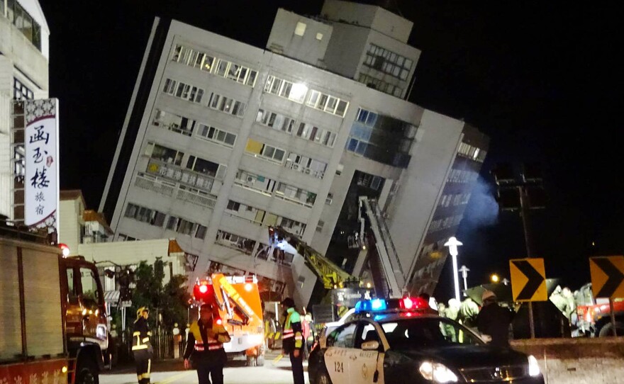 Rescuers are seen entering a building that collapsed onto its side from an early morning earthquake in Hualien County, eastern Taiwan, on Wednesday. The quake's magnitude was 6.4.