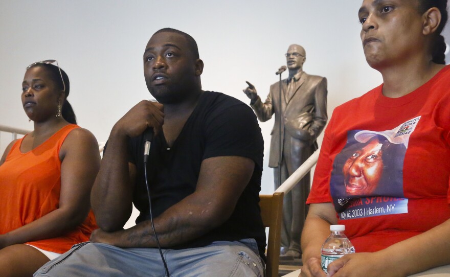 Delrawn Small's companion Zaquanna Albert, left, and his brother Victor Demsey, center, and Cynthia Howell, right, an advocate with Families United for Justice, an organization made up of families affected by police killings, attend a news conference Thursday July 14, 2016 in New York.