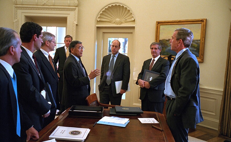 Secretary of Transportation Norman Mineta (hand raised on left) speaks with President George W. Bush (right) and other officials in the Oval Office. Oct. 30, 2001.