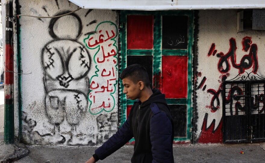 A man walks near a mural of Handala in the village of al-Fara, in the occupied West Bank, following an Israeli raid on Dec. 8.