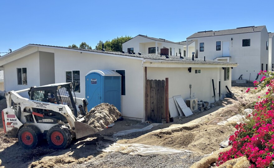 A tractor moves dirt on the construction site of an ADU bonus project, May 21, 2025.