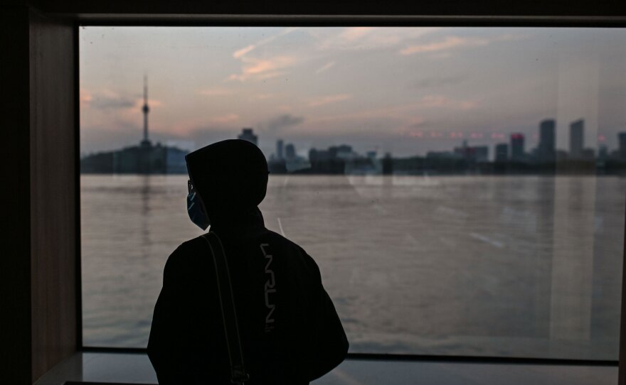 A man wearing a face mask travels on a ferry to cross the Yangtze River in Wuhan in April. Chinese officials are working to silence people suspected of challenging the narrative that authorities in Wuhan and Beijing acted swiftly and efficiently to contain the coronavirus outbreak.