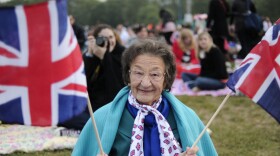 A fan holds British Union Jack flags as people gather to watch the wedding of Britain's Prince William and Kate Middleton on big screens in Hyde Park in central London.