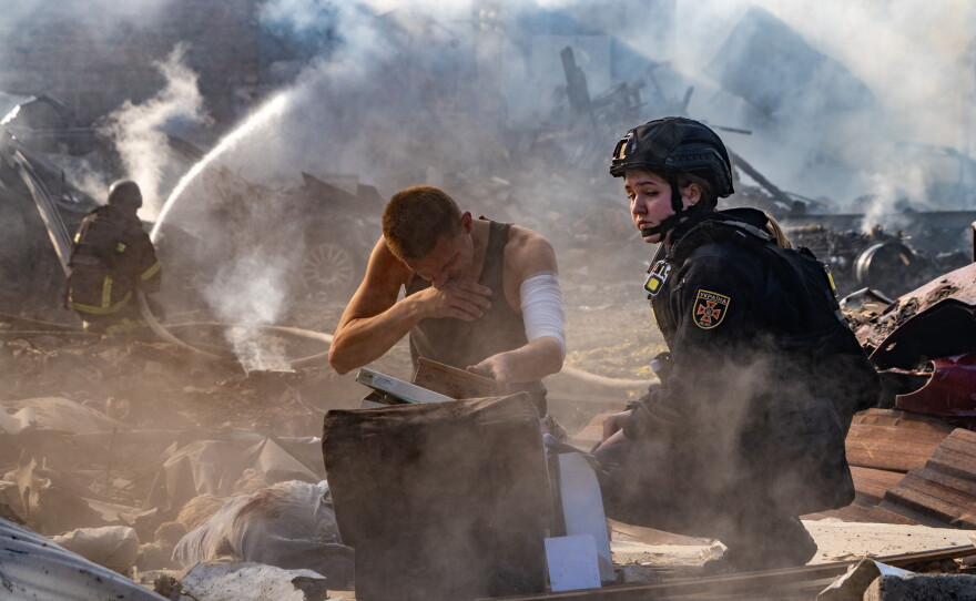 An injured man collects his personal belongings in front of his house destroyed in a Russian strike on Kharkiv, Ukraine, Sunday, Oct. 11, 2026.