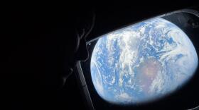 NASA astronaut and Artemis II Commander Reid Wiseman looks at Earth through Orion's main cabin windows as the crew travels towards the Moon. Wiseman and his three crewmates are set to return to Earth on Friday.