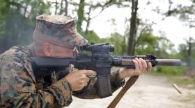 Christian Wade of the 2nd Marine Division at Camp Lejeune shoots a suppressed carbine. The surpressor is the canister on the end of the barrel.