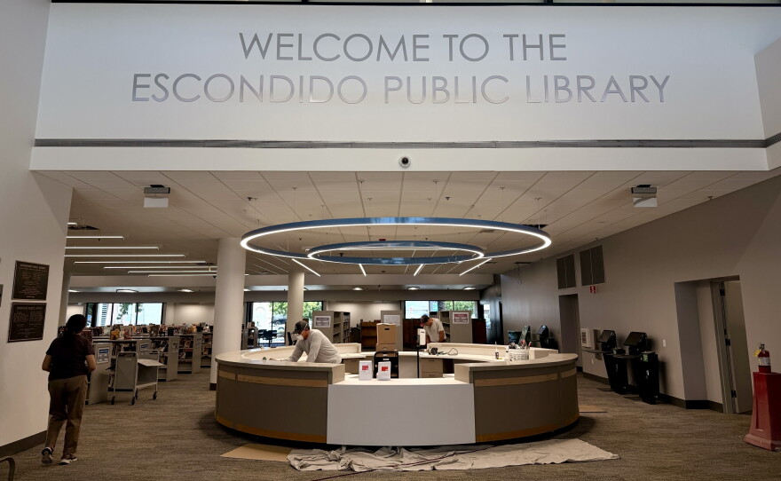 Construction workers finish the welcome desk for the renovated Escondido Public Library, July 14, 2026.