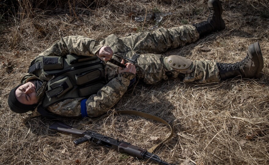 A member of a Territorial Defense unit practices putting on a tourniquet at a defensive position on the outskirts of Kyiv on Thursday.