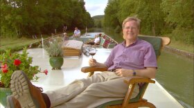 With his all-new series, Rick Steves (hard at work here cruising a canal in Burgundy) finds and shares the good life in Europe. 
