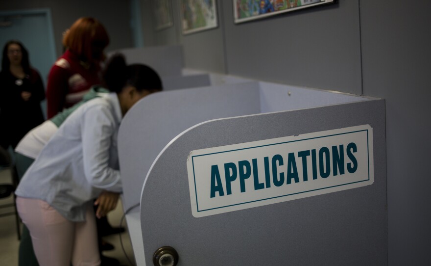 Job seekers fill out applications inside the employment center at the Six Flags Entertainment Corp. Great Adventure amusement park in Jackson, N.J., in March.