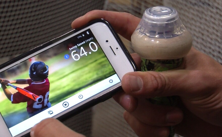 Blast Motion's swing analyzer (right) is synced via bluetooth to a phone providing real-time metrics, June 1, 2016.