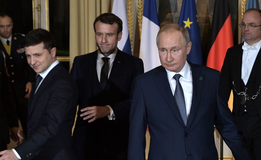 Ukrainian President Volodymyr Zelenskiy, French President Emmanuel Macron and Russian President Vladimir Putin arrive for a meeting on Ukraine with German Chancellor at the Elysee Palace on Monday in Paris.