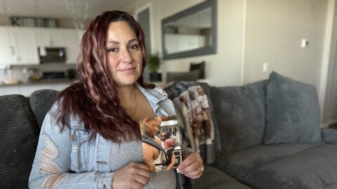 Britny Calloway holds a photograph of her husband, James Calloway, and their son in her home on Thursday, Jan. 15, 2026.