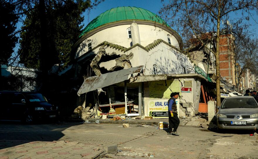A man walks past a collapsed mosque in Adiyaman, Turkey on Thursday, three days after a 7,8-magnitude earthquake struck Turkey and Syria.