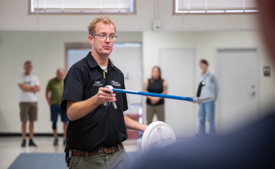 Cale Morris of the Phoenix Herpetological Society holds snake tongs as he leads a class on rattlesnakes at the Florence Ely Nelson Desert Park in Scottsdale, Arizona, U.S., May 14, 2024. Morris demonstrated ways to safely interact with a rattlesnake in order to relocate and release them without hurting them or getting bitten.