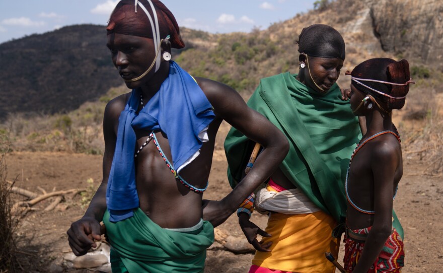Three morans hang out at their campsite: Ltesekwa (center), Leseu Mareketo (left) and Lepenari Lepeni. The beaded ornaments they wear mark them as morans.