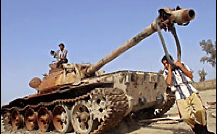 A boy uses the cannon of a destroyed Iraqi army tank as a swing on March 18, 2006, near Basra. Defeating the Iraqi military turned out to be easier than bringing peace and stability back to the country after the invasion.