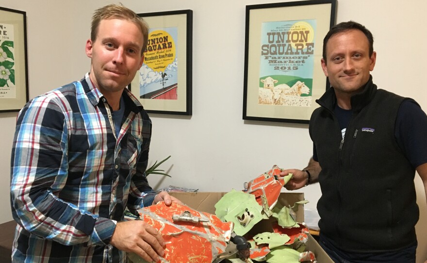 Isaac Stoner (left) and Dan Futrell, with a box of plane parts at Futrell's Somerville apartment.