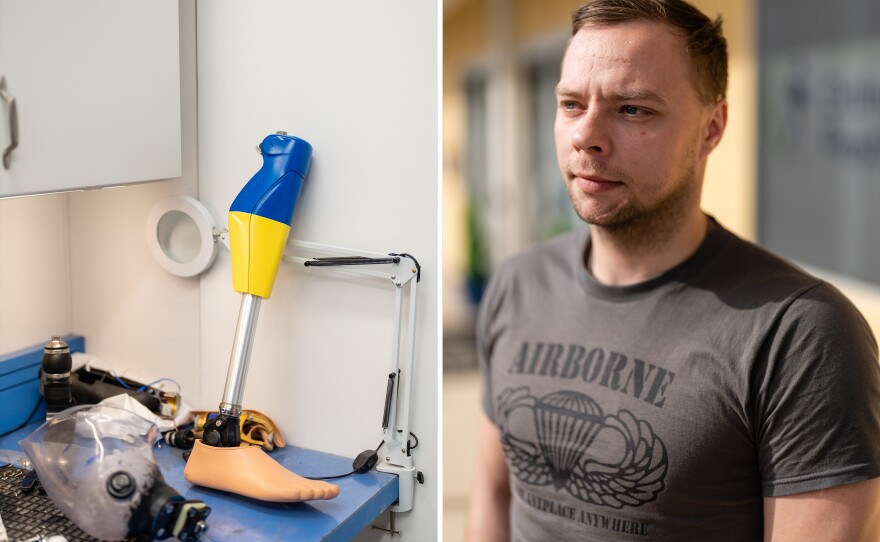 Oleksandr Fedun stands next to a prosthesis designed with the colors of the flag of Ukraine in the workshop.