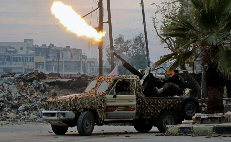 Fighters of the Free Syrian Army fire an anti-aircraft weapon in Aleppo's rebel-held area of Mashhad on Monday, as they battle Syrian government forces.