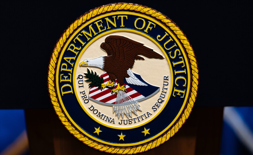 FILE - The U.S. Department of Justice logo is seen on a podium before a news conference, May 4, 2026, in Washington.