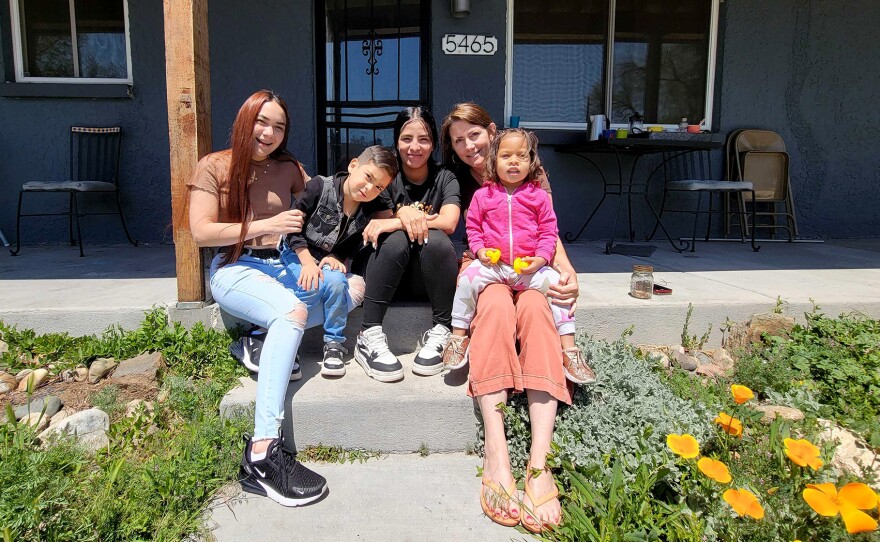 Hengarlyth Jimenez (left to right) and her son, Alan, Neydira López and her daughter, Fabiola, and Mountain View Mayor Emilie Mitcham sit in front of Mitcham's duplex, which she's opened to the mothers as they pursue their own futures in Colorado. May 4, 2024.