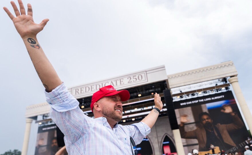 A person worships to Christian music at Rededicate 250, a mostly conservative Christian prayer gathering in honor of the United States' 250th anniversary, on the National Mall on Sunday.
