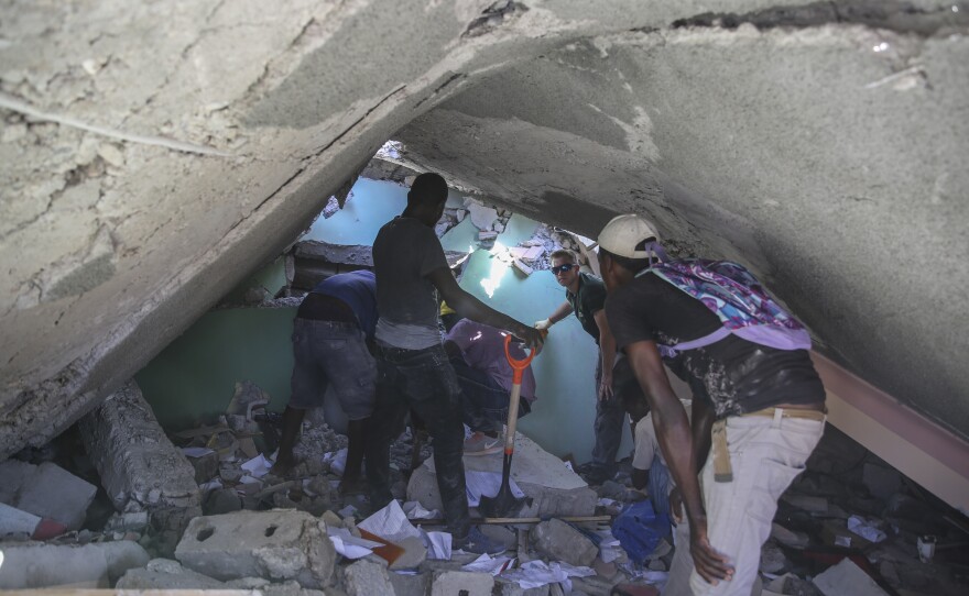 <strong>Sat., Aug. 14:</strong> People search for survivors in a home destroyed by the earthquake in Les Cayes, Haiti.