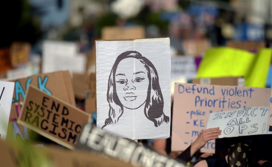 Protesters march with placards and a portrait of Breonna Taylor during a demonstration against racism and police brutality this month in Hollywood, Calif. The mayor of Louisville, Ky., has announced that an officer involved in her death will be fired.
