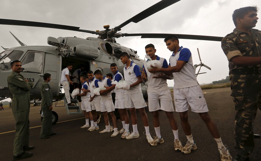 At Chennai's Tambaram Air Force Station, soldiers load food supplies onto a chopper in advance of air-drop on Friday.
