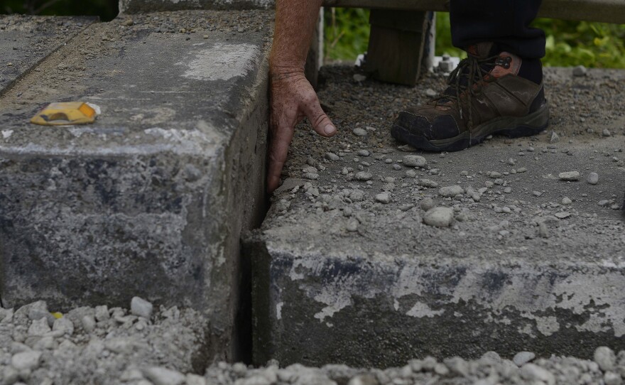 An emergency services worker inspects a bridge crossing the Waiau River in New Zealand on Monday, after a powerful earthquake on Sunday caused widespread infrastructure damage.