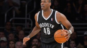 Brooklyn Nets center Jason Collins dribbles the ball during the second half of an NBA basketball game against the Los Angeles Lakers, Feb. 23, 2014, in Los Angeles.