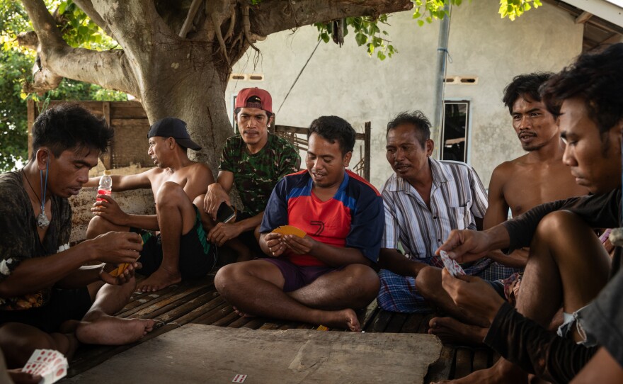Fishermen play a card game on June 10, 2025, on Maringkik Island, off the caost of East Lombok, Indonesia.