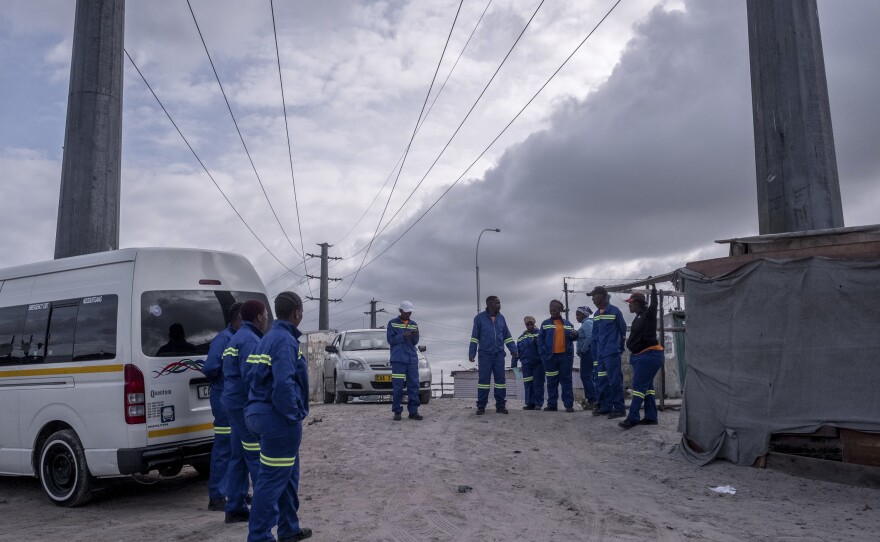 A group of janitors, standing in a parking lot, say they lack the cleaning products needed to take care of communal toilets in the township of Khayelitsha. Each public toilet is used by dozens of people every day.